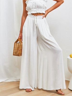 White gathered waist wide-leg palazzo maternity pants with drawstring and ruffle detail.