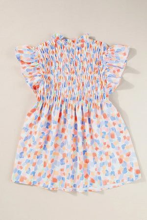 Smocked bodice blouse with brushstroke print and flutter sleeves in pastel colors.