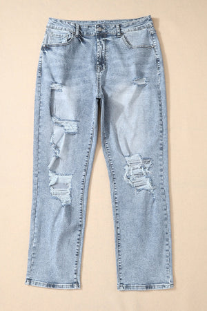 Light wash distressed denim jeans with a slim leg cut and ripped details.