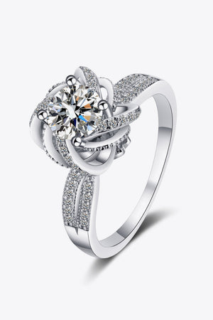 Silver ring with a floral halo moissanite center and pave diamond band.