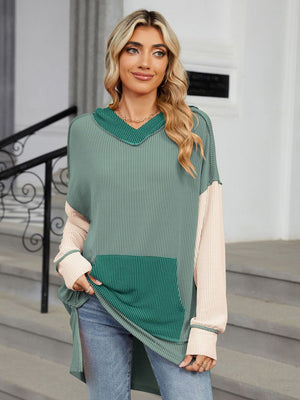 Waffle knit tunic with colorblock design, hood, and pocket.