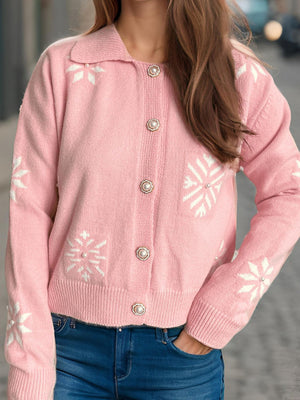 Blush pink knit cardigan with snowflake pattern and pearl buttons.