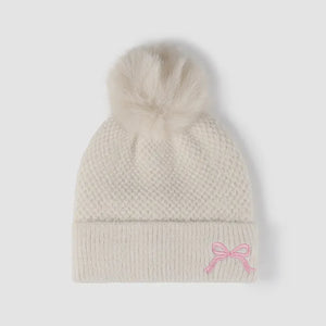 Beige knit beanie with pom-pom and pink bow detail