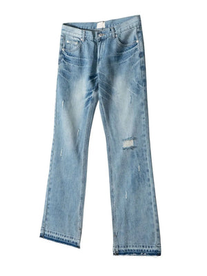 Split-hem distressed denim jeans in medium wash with raw hem detail.