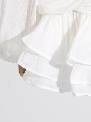 White ruffle mini dress with balloon sleeves and a twisted detail.