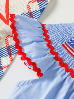 Baby smocked top with red ric-rac trim and embroidered flag detail.