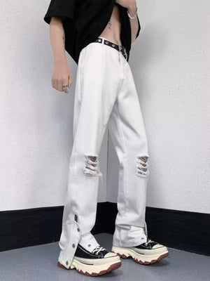 White distressed loose-fit jeans with snap detail at the hem and ripped knees.