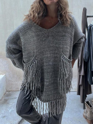 Dark gray knit poncho sweater with V-neck, fringed pockets, and a relaxed fit.