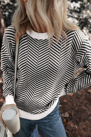 Chevron knit crewneck sweater in black and white with white trim.