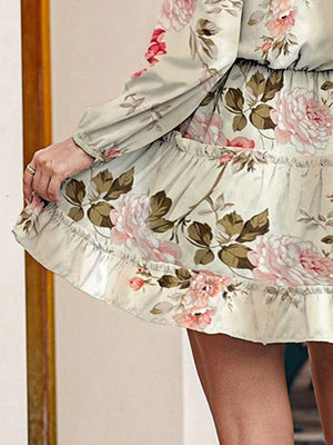 Ivory floral print tiered mini dress with ruffled hem and long sleeves.