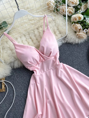 Pink V-neck spaghetti strap mini dress with adjustable straps and a draped bodice.
