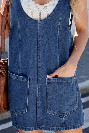 Sculpted denim mini dress in medium wash with front pockets and a scoop neckline.