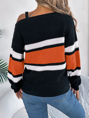 Asymmetric stripe knit sweater with one shoulder strap detail in black, orange, and white.