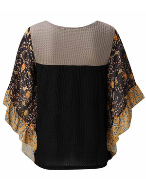 Textured panel blouse in black with floral print flutter sleeves and ruffled trim.