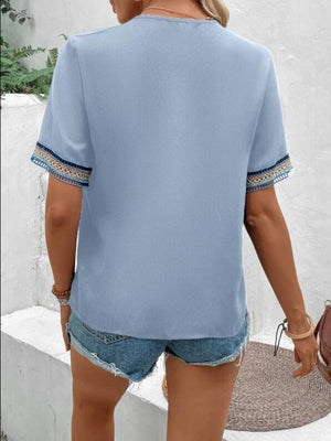 Light Blue V-neck top with embroidered trim on short sleeves.