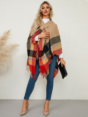 Asymmetric plaid fringe cape in tan and red with fringed hem.