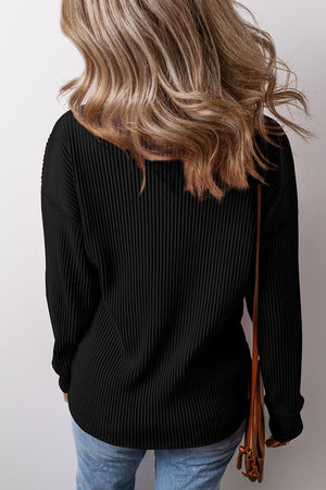 Black ribbed knit long sleeve top with a relaxed fit.