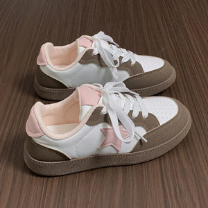 Retro court sneakers in white with blush pink star appliqué and brown accents.