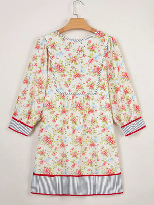 Floral cotton dress with puff sleeves, contrast trim, and striped hem.