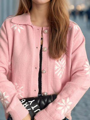 Blush pink knit cardigan with snowflake pattern and pearl buttons.