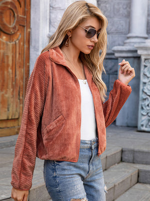 Textured corduroy zip-up jacket in terracotta with collar and pockets.