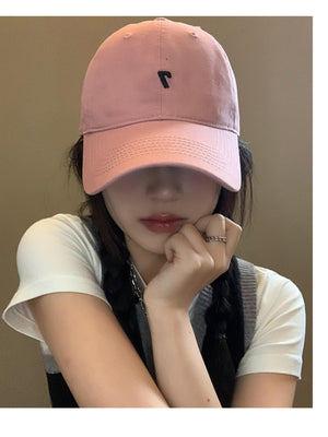 Pink cotton baseball cap with black embroidered detail and stitched brim.