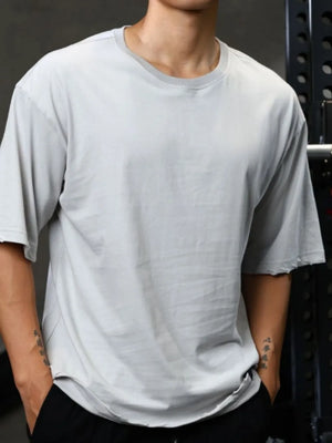 Distressed oversized gray t-shirt with raw edges and a crew neck.
