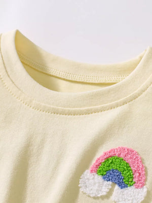 Baby dress in beige cotton with a textured rainbow applique on the chest.