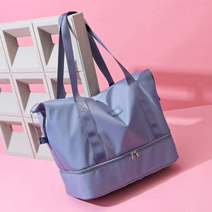 Dusty Blue dual-compartment travel tote with metallic trim and dual zippers on bottom compartment.