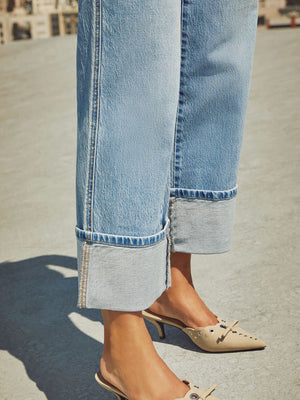 Light wash denim jeans with wide legs and large cuffs.