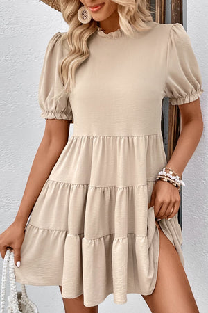 Beige tiered mini dress with ruffled neckline and puff sleeves.