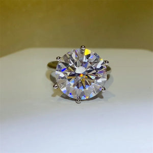 Silver solitaire ring with a large, faceted clear gemstone and six prong setting.