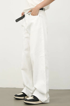 Sculpted wide leg denim trousers in ivory, styled with a belt and sneakers.