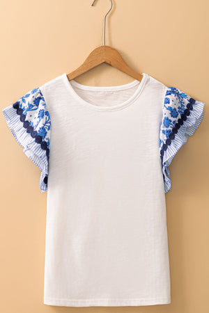 White tee with blue floral embroidered flutter sleeves and ruffled trim.