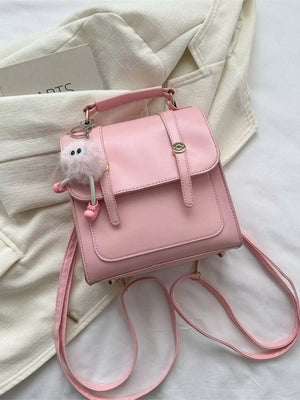 Chic blush pink PU leather mini backpack with cute fuzzy charm and gold hardware.