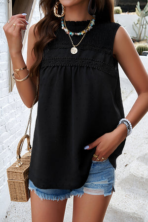 Black sleeveless tank top with textured yoke and dot pattern, ruffled mock neck.