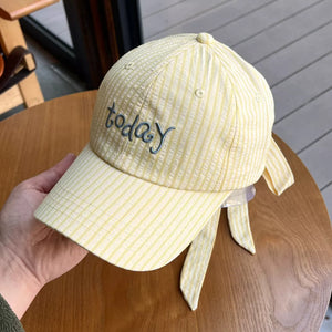 Yellow pastel striped cotton baseball cap with "today" embroidery and bow detail.