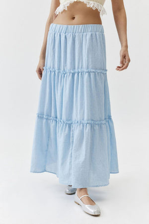 Tiered cotton maxi skirt in light blue with elastic waistband and ruffled tiers.