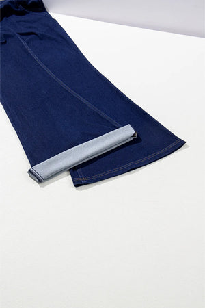 Medium wash denim flare trousers with a rolled hem detail.