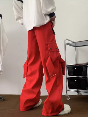 Men's red relaxed-fit cargo pants with multiple pockets and silver stud details.