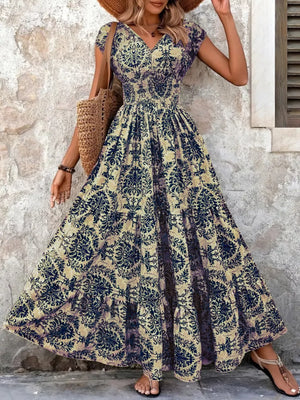 Maxi dress with smocked bodice, v-neck, short sleeves, and tiered skirt in a dark blue floral pattern.