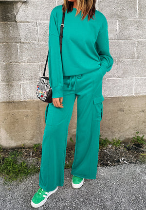 Turquoise cargo pocket lounge set with crewneck sweatshirt and wide leg pants.