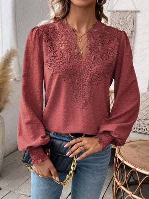 Embroidered yoke blouse in rust with puff sleeves and textured fabric.