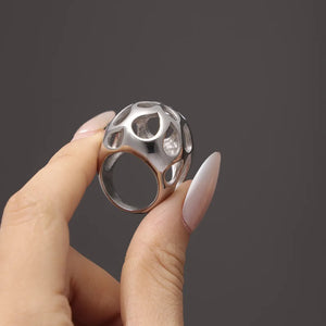 Silver openwork orb ring with contemporary geometric cutouts.