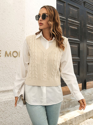 Ivory cable knit crop vest sweater with V-neck, layered over a white button-down shirt.