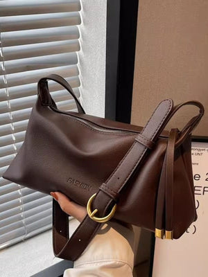 Soft slouchy crossbody bag in coffee color with adjustable strap and gold buckle detail.