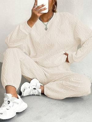 Beige cable knit loungewear set with crewneck sweater and cuffed joggers.