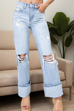 Distressed cuff wide-leg light wash denim jeans with ripped knees and cuffed hems.