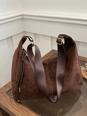Brown suede crossbody bag with adjustable strap and drawstring detail