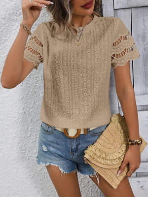 Beige eyelet blouse with scalloped short sleeves and intricate patterned fabric.